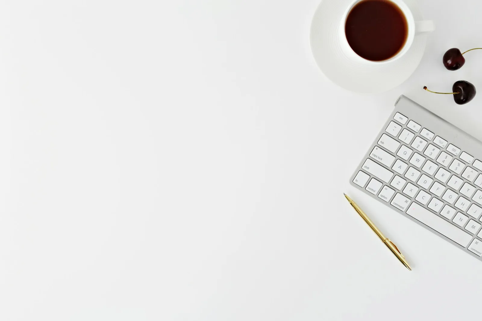 Keyboard, pen and cup on a desk